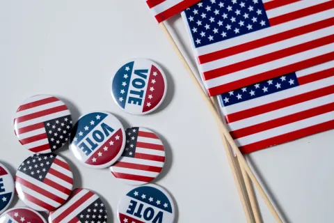 Three American flags with buttons of flags and the word "vote"