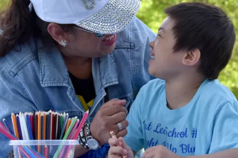 woman in a hat and a child looking at each other