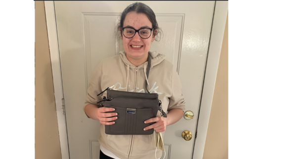 Photo of Alyson holding the bag she keeps her wallet in when she goes out shopping