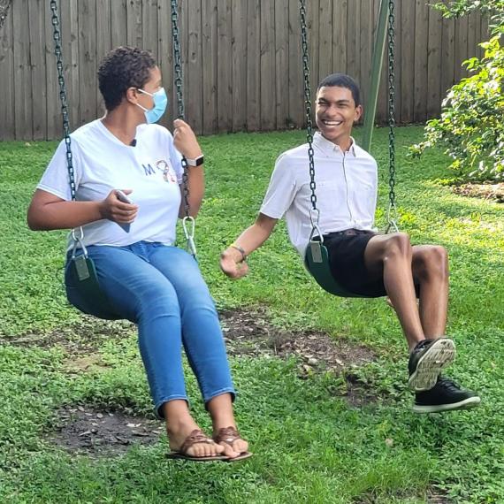 Blogger Michelle swinging on a swing set with her son, Justin. Justin has a big smile on his face.