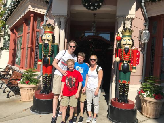 Jeff McCafferty, his wife and two sons in front of life size nut crackers