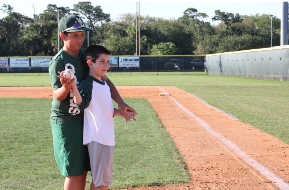 Two brothers stand to throw out the first pitch