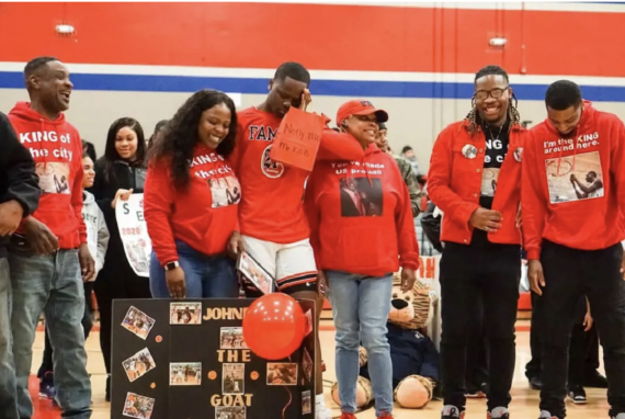 A basketball player in a red jersey cries with his sister for support during an autism celebration 
