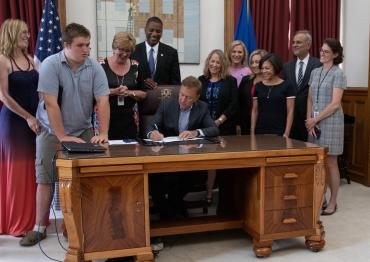 Governor Lamont signing bill and surrounded by advocates