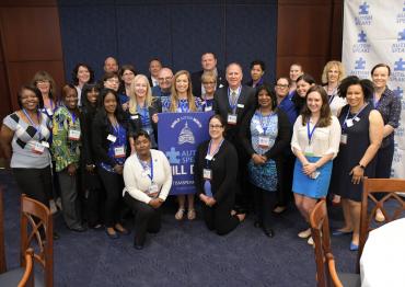 Group of 25+ Advocacy Ambassadors standing with World Autism Month Hill Day sign