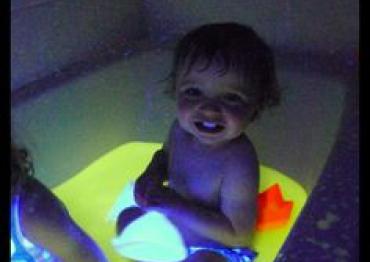 baby sitting in safe edible glow water for sensory fun