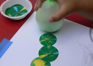 child playing with DIY sensory balloon painting stamp
