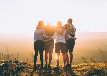 group of friends watching a sunset after a hike