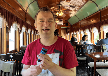 man in a red shirt sitting in a train