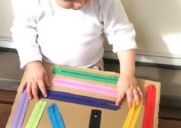 toddler playing with a diy sensory zipper board