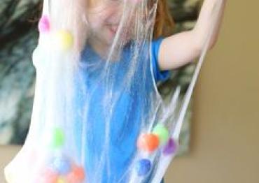 toddler playing with a polka dot sensory slime toy