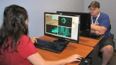 2 people sitting at laptops during the NXT Gen Coders Program powered by GameStop