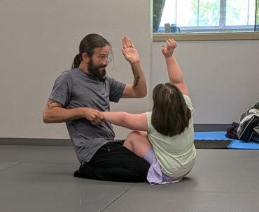 Amelie working with John Smith, owner and coach at New Strength Adaptive Fitness