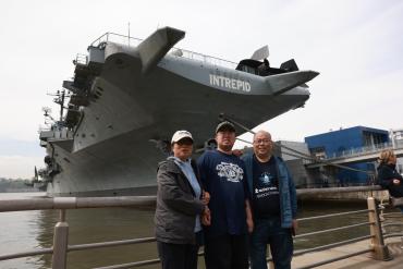 Feng family standing in front of Intrepid ship