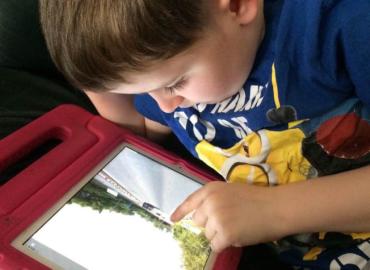 Isaac using an iPad to look at Google Maps