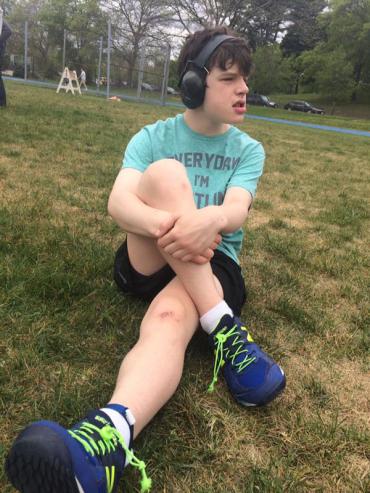 Jack wearing headphones and stretching before a soccer game