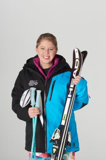 Kayla C. holding her ski equipment