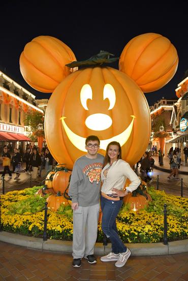 Kimberly Mariajimenez and her son Blake standing in front of a Mickey Mouse pumpkin in Disney