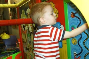 Lisa Smith's son wearing a red shirt with stripes at an indoor play place