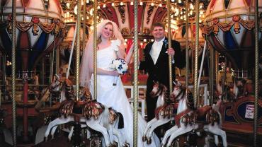 Ron Sandison and his wife standing on a carousel on their wedding day