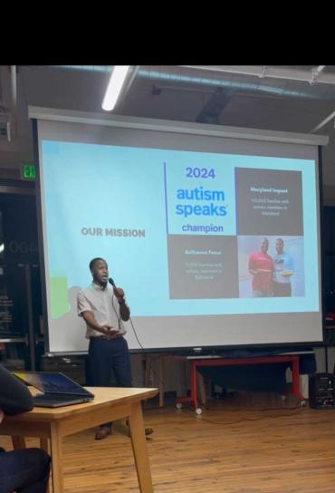 N'Kobe presenting and speaking on a microphone