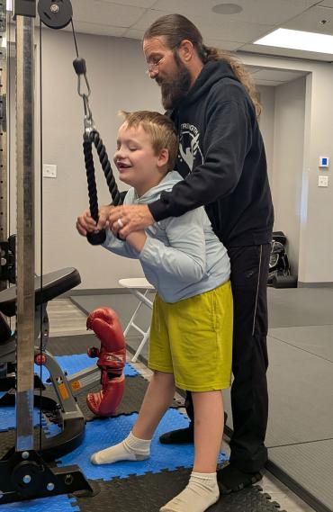 Percy working with owner and coach at New Strength Adaptive Fitness