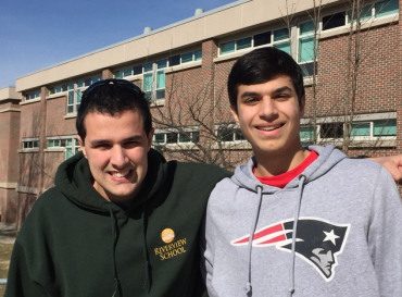 Two you men smile outside of school