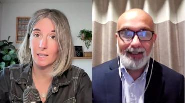 Woman wearing a dark grey jacket having a conversation via a virtual platform with a man wearing glasses, a dark blue jacket, and a light blue shirt. 