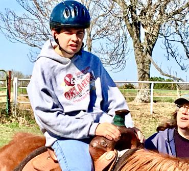 Trey wearing a helmet while riding a horse