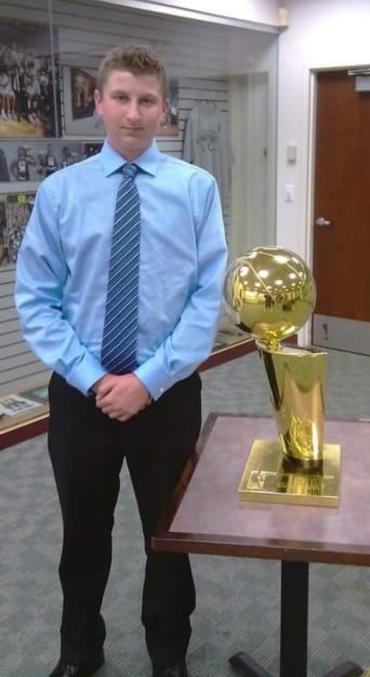 Tyler Marcotte standing next to a trophy