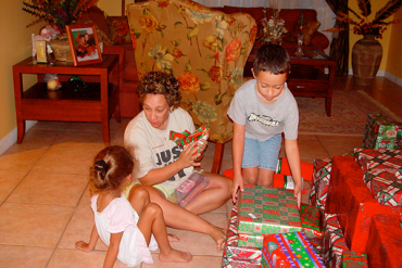 a family around the Christmas tree opening presents