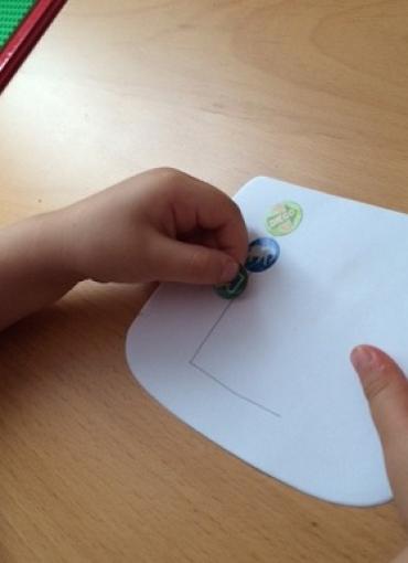 a toddler putting stickers on paper