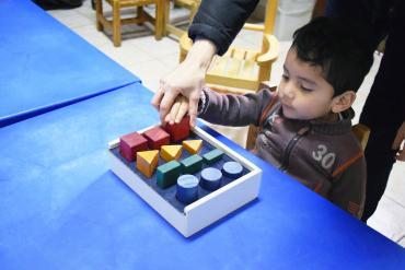 a toddler touching colorful blocks during occupational therapy