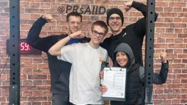 a family flexing their muscles during a CrossFit workout