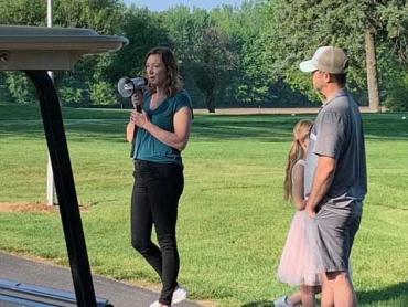 a woman with a megaphone on a golf course