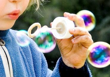 blonde toddler blowing bubbles