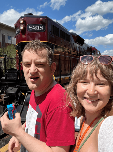brother and sister taking a selfie near a train
