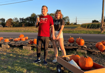 brother and sister with a wagon of pumpkins at a pumpkin patch