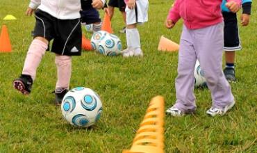 toddler soccer team kicking a soccer ball