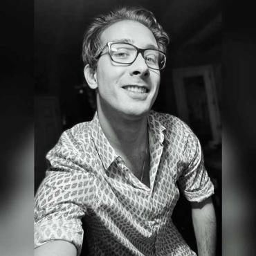 man wearing glasses and taking a selfie with a black and white filter