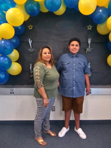 mother and son standing under a balloon arch