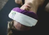a woman laying down and relaxing with an eye mask
