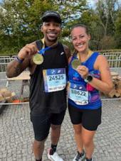 a man and a woman holding up Autism Speaks medals after an endurance event