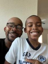 a man in glasses hugging his son