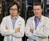 two male researchers in white lab coats with their arms crossed
